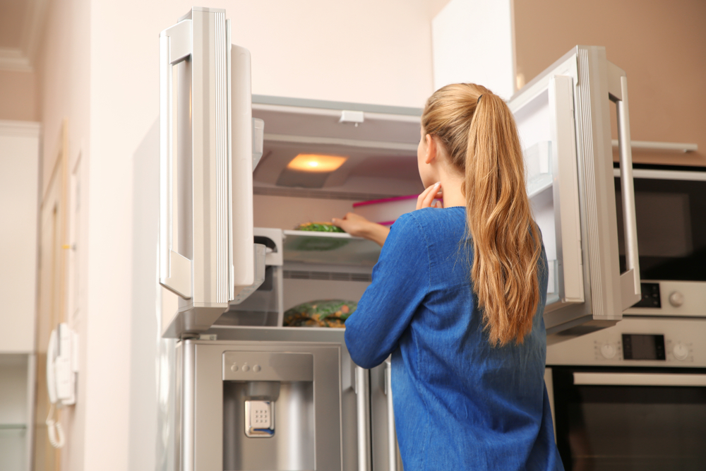 Young,Woman,Choosing,Food,In,Refrigerator,At,Home